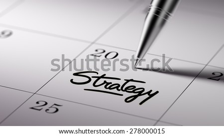 Closeup of a personal agenda setting an important date written with pen. The words Strategy written on a white notebook to remind you an important appointment.