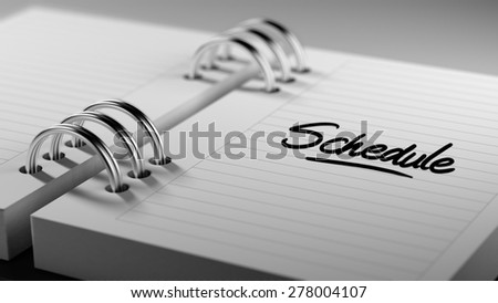 Closeup of a personal agenda setting an important date representing a time schedule. The words Schedule written on a white notebook to remind you an important appointment.