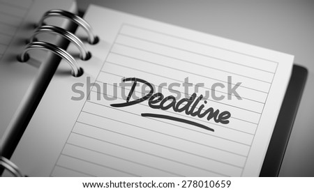 Closeup of a personal agenda setting an important date representing a time schedule. The words Deadline written on a white notebook to remind you an important appointment.