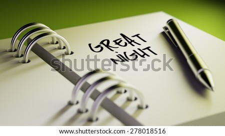 Closeup of a personal agenda setting an important date writing with pen. The words Great Night written on a white notebook to remind you an important appointment.