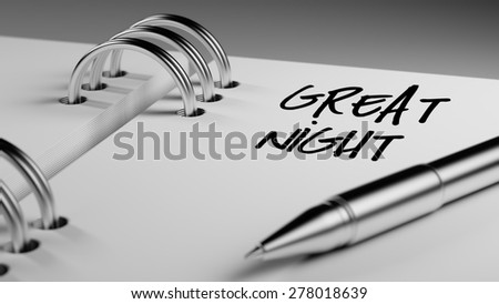 Closeup of a personal agenda setting an important date writing with pen. The words Great Night written on a white notebook to remind you an important appointment.