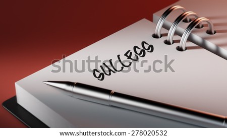 Closeup of a personal agenda setting an important date writing with pen. The words Success written on a white notebook to remind you an important appointment.