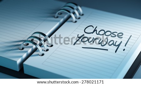 Closeup of a personal agenda setting an important date representing a time schedule. The words Choose your way written on a white notebook to remind you an important appointment.