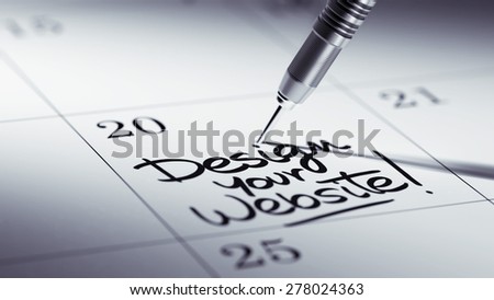 Concept image of a Calendar with a golden dart stick. The words Design your website written on a white notebook to remind you an important appointment.