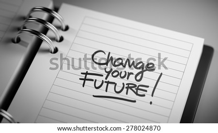 Closeup of a personal agenda setting an important date representing a time schedule. The words Change your future written on a white notebook to remind you an important appointment.