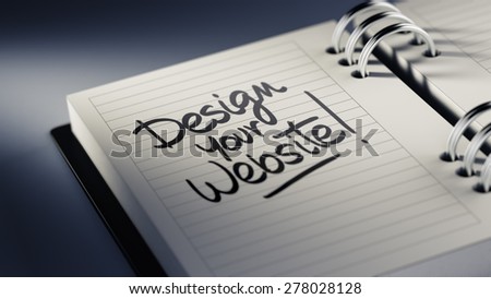 Closeup of a personal agenda setting an important date representing a time schedule. The words Design your website written on a white notebook to remind you an important appointment.