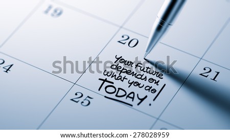 Closeup of a personal agenda setting an important date written with pen. The words Your future depends on what you do today written on a white notebook to remind you an appointment.