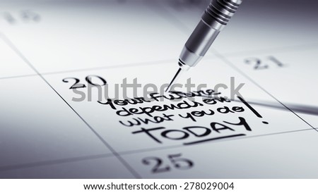 Concept image of a Calendar with a golden dart stick. The words Your future depends on what you do today written on a white notebook to remind you an appointment.