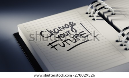 Closeup of a personal agenda setting an important date representing a time schedule. The words Change your future written on a white notebook to remind you an important appointment.