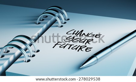 Closeup of a personal agenda setting an important date writing with pen. The words Change your future written on a white notebook to remind you an important appointment.