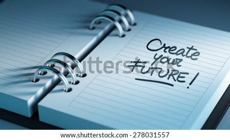 Closeup of a personal agenda setting an important date representing a time schedule. The words Create your future written on a white notebook to remind you an important appointment.