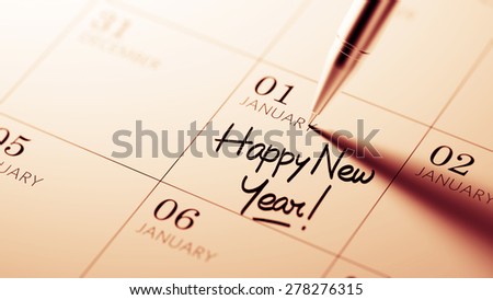 Closeup of a personal agenda setting an important date written with pen. The words Happy New Year written on a white notebook to remind you an important appointment.