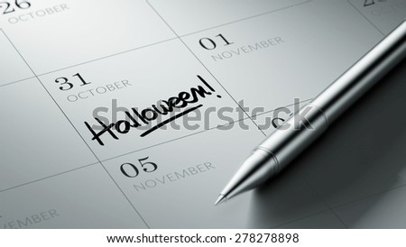 Closeup of a personal agenda setting an important date written with pen. The words Halloween written on a white notebook to remind you an important appointment.