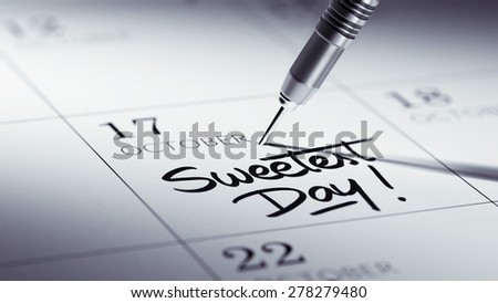 Concept image of a Calendar with a golden dart stick. The words Sweetest Day written on a white notebook to remind you an important appointment.