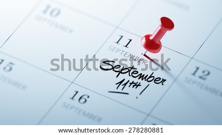 Concept image of a Calendar with a red push pin. Closeup shot of a thumbtack attached. The words September 11th written on a white notebook to remind you an important appointment.