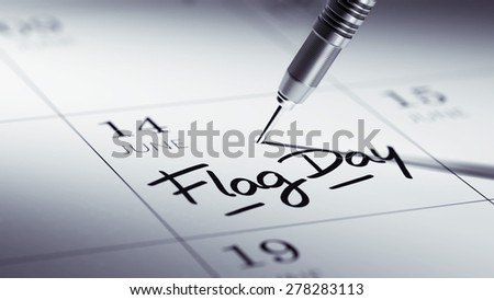Concept image of a Calendar with a golden dart stick. The words Flag Day written on a white notebook to remind you an important appointment.