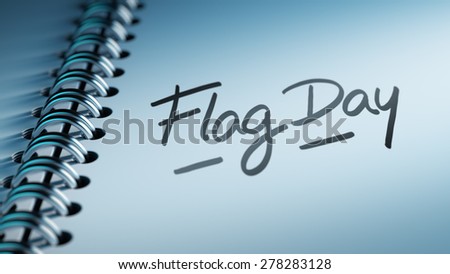 Closeup of a personal calendar setting an important date representing a time schedule. The words Flag Day written on a white notebook to remind you an important appointment.