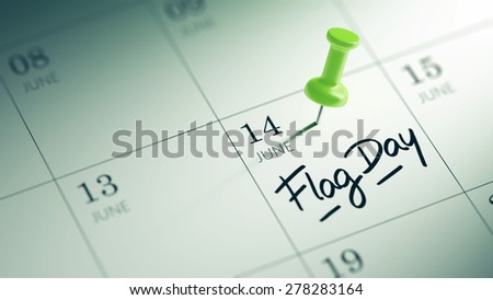 Concept image of a Calendar with a green push pin. Closeup shot of a thumbtack attached. The words Flag Day written on a white notebook to remind you an important appointment.