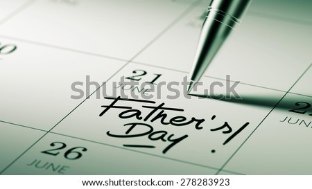 Closeup of a personal agenda setting an important date written with pen. The words Father\'s Day written on a white notebook to remind you an important appointment.