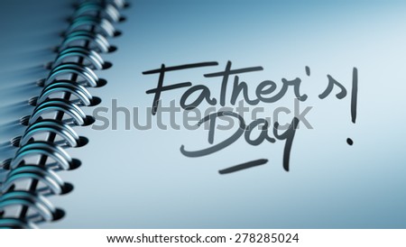 Closeup of a personal calendar setting an important date representing a time schedule. The words Father\'s Day written on a white notebook to remind you an important appointment.