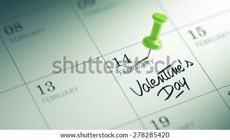 Concept image of a Calendar with a green push pin. Closeup shot of a thumbtack attached. The words Valentine\'s Day written on a white notebook to remind you an important appointment.
