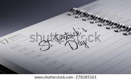 Closeup of a personal calendar setting an important date representing a time schedule. The words St. Patrick\'s Day written on a white notebook to remind you an important appointment.