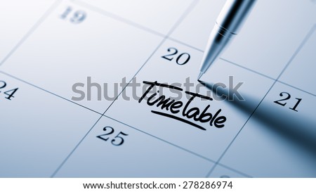 Closeup of a personal agenda setting an important date written with pen. The words Timetable written on a white notebook to remind you an important appointment.