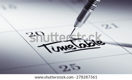Concept image of a Calendar with a golden dart stick. The words Timetable written on a white notebook to remind you an important appointment.
