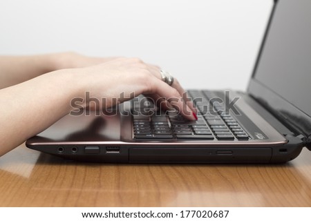 typing with both hands on the laptop keyboard