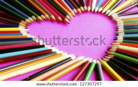 A pink heart made from colored pencil tips