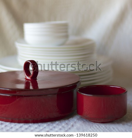 Red Bowls with a Stack of White Plates in the Background