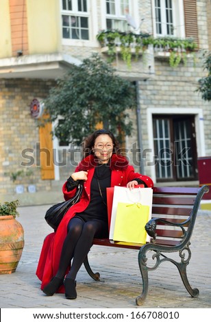 A woman with a shopping bag, sitting in the business district long chair