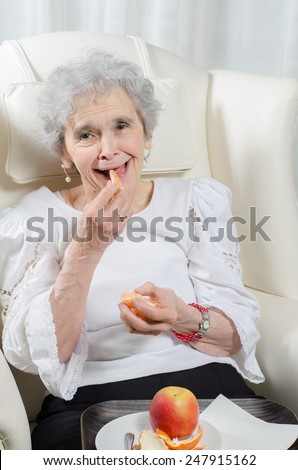 old woman eating tangerine
