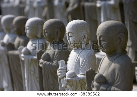 Group of meditating buddhas, selective focus on the white statue.