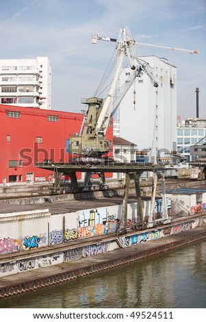Old commercial dock with rusty cranes at the Rhine river bank in Basel/Switzerland.