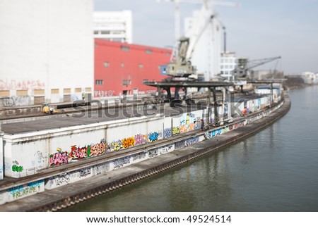 Old commercial dock at river Rhine at Basel. Selective Focus with Tilt/Shift-Lens on the colorful graffities.