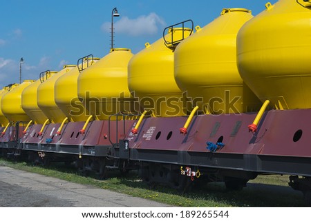 Freight Train with yellow tanks sitting on railroad tracks