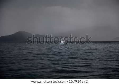 Lone boat in the storm on Andaman sea close to Railay Beach, Krabi, Thailand
