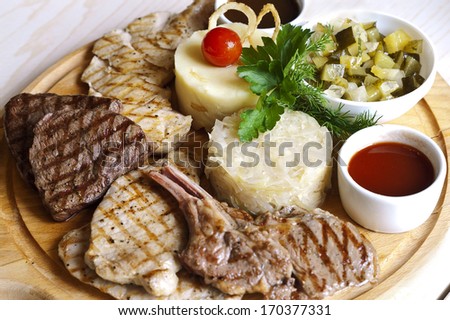 assorted fried meat laid on the wooden tray, overhead shot focused on center