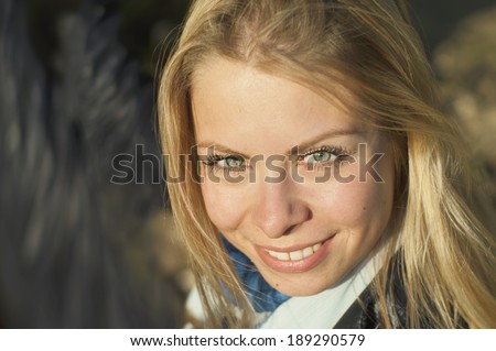 Portrait of a happy beautiful woman in direct sun light with abstract blurred background