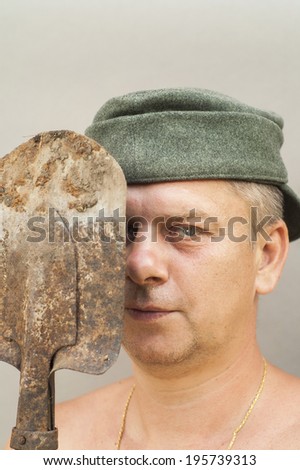 Man in a hat holding a shovel, concept of a hard labor