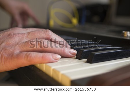 Closeup of female musician hand playing synthesizer