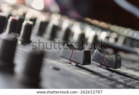 Macro shot of mixing console sliders, indoor horizontal composition with a shallow depth of field