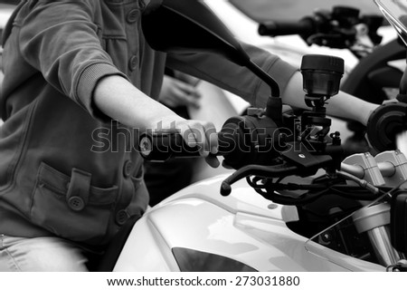 Driving motorcycle, child hand on a throttle control, horizontal black and white image