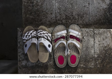 Two pairs of well used walking shoes on a stone stair, concept of healthy lifestyle, overhead shot