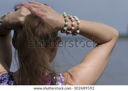 Woman dreaming with hands over her head, back shot with blurred foreground and background