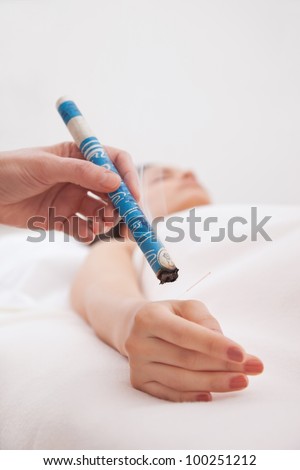 TCM Traditional Chinese Medicine, hand applying moxa stick