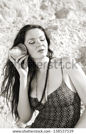 summer portrait of attractive woman listening the sound of sea