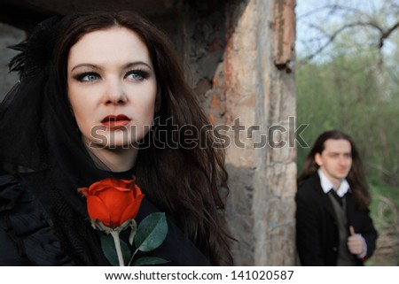 young woman in old style black dress and young man