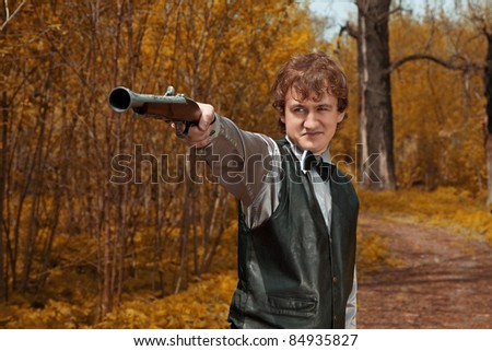 man pull on gun trigger. outdoor shot